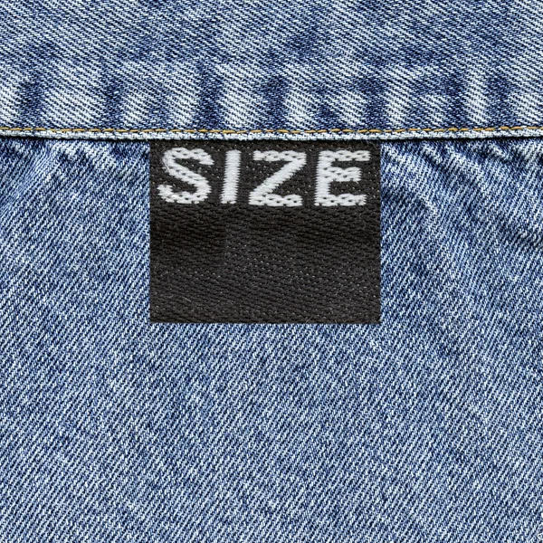 Etiqueta negra y textura de jeans azules — Foto de Stock