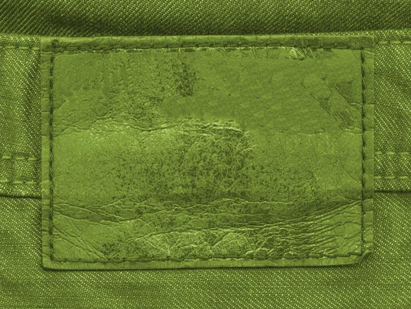 Label on green denim background — Stock Photo, Image