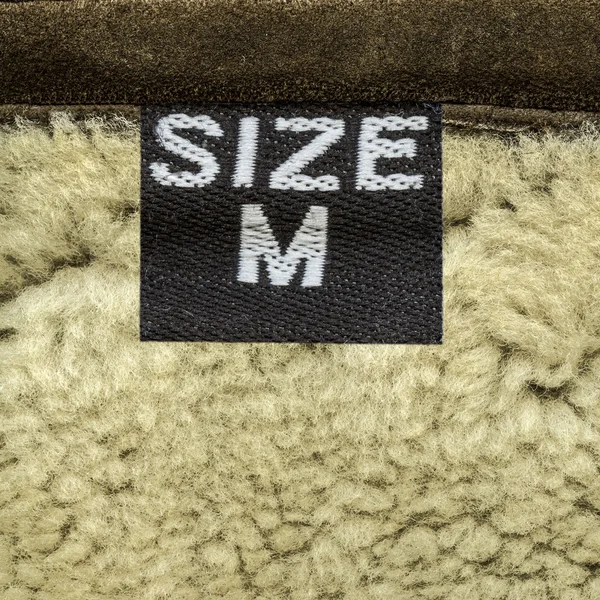 Sheepskin closeup, tag, size — Stock Photo, Image