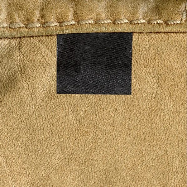 Light brown leather texture, seam, label — Stock Photo, Image