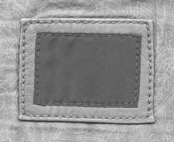 этикетка кожи и текстиля на сером текстильном фоне
