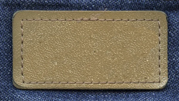 Etiqueta de jeans de couro branco marrom no fundo de jeans — Fotografia de Stock