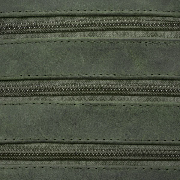 Zöld bőr háttér díszített cipzárak — Stock Fotó