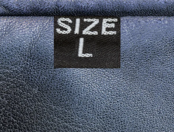 Texture en cuir bleu, étiquette textile, taille — Photo