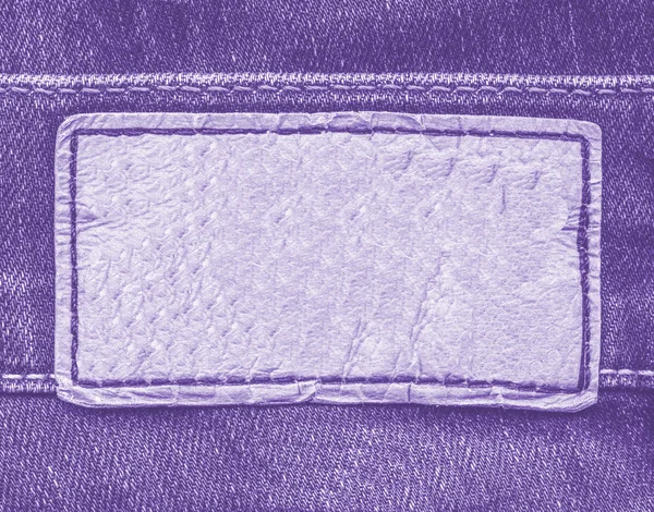 Violettes Leder-Etikett auf violettem Jeans-Hintergrund — Stockfoto