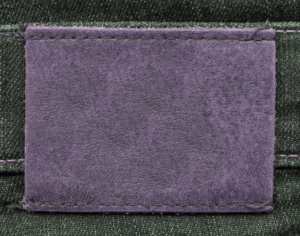Violet lederen label op jeans achtergrond — Stockfoto