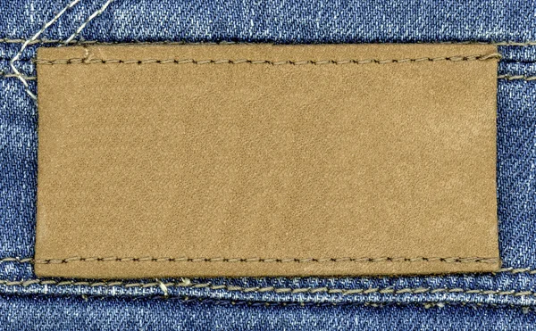 Hellbraunes leeres Lederetikett auf Jeans-Hintergrund — Stockfoto