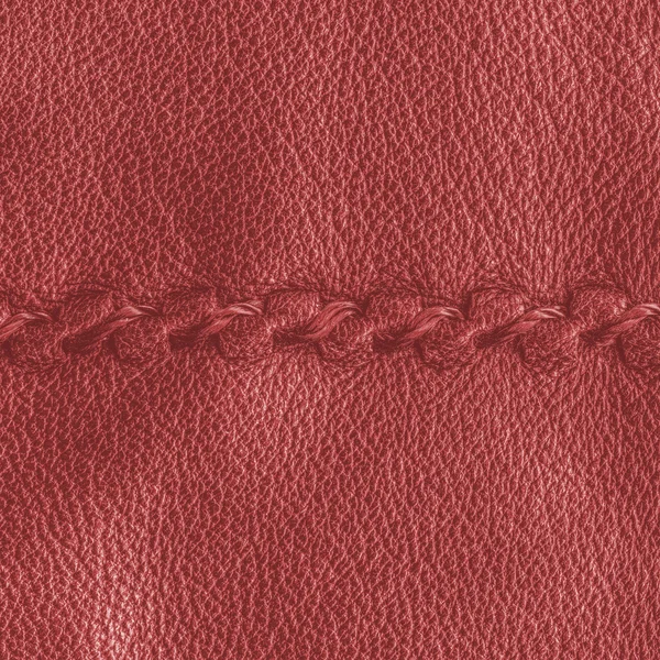 Red leather texture decorated with seam — Stock Photo, Image