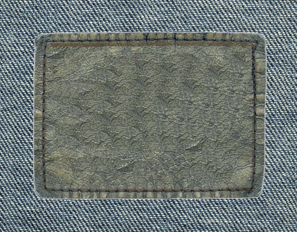 Blank leather label on pale blue denim background — Stock Photo, Image