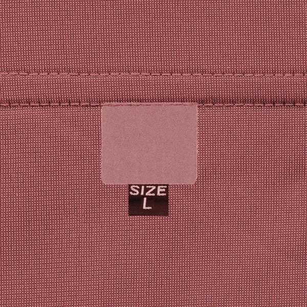 Etiqueta textil roja sobre fondo de tela roja — Foto de Stock