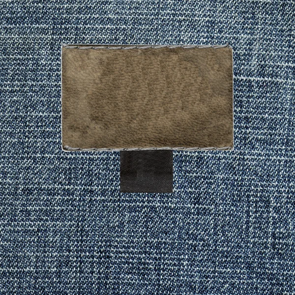 Texture denim blu, etichetta in pelle bianca — Foto Stock