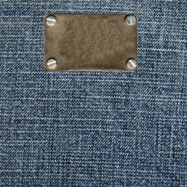 Textura azul denim, etiqueta de couro em branco — Fotografia de Stock
