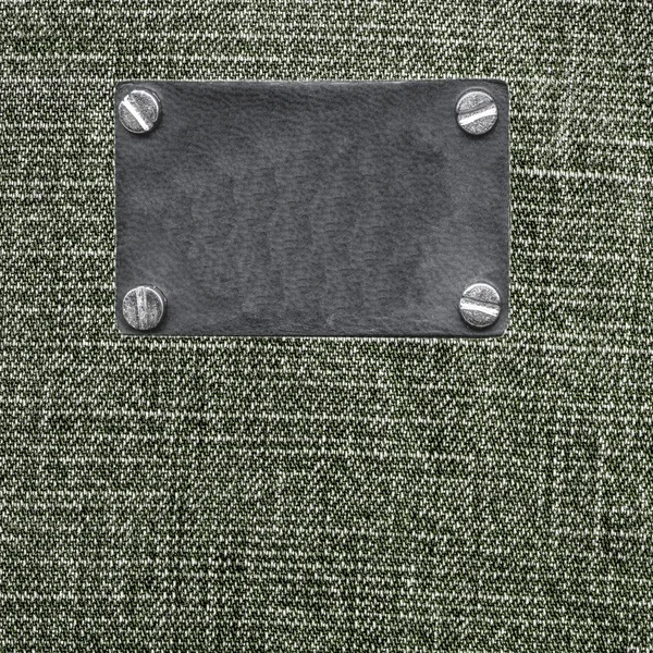 Textura denim cinza-verde, etiqueta de couro em branco — Fotografia de Stock