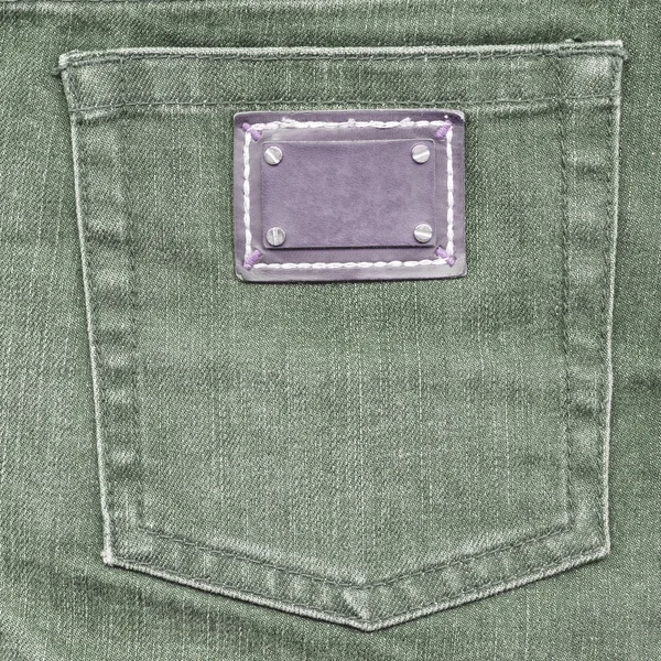 Green jeans back pocket, violet label — Stock Photo, Image