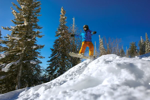 Salto snowboarder su snowboard — Foto Stock