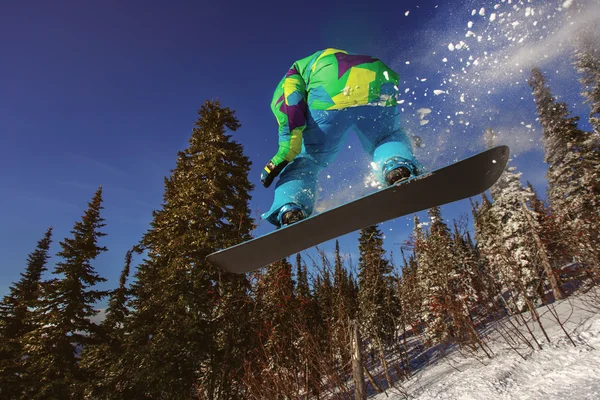 Snowboarder saltando em montanhas de inverno — Fotografia de Stock