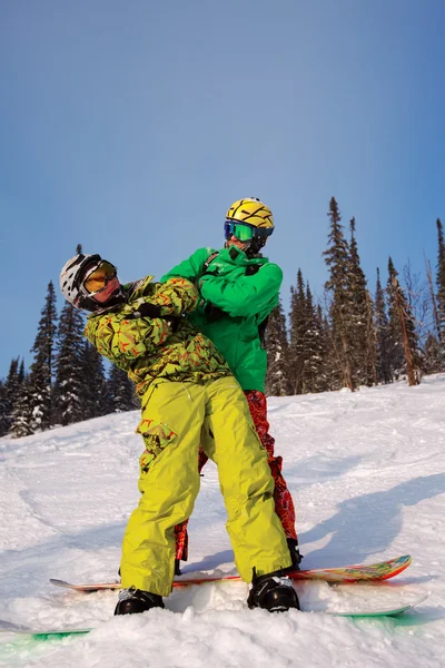 Mladý pár se baví s snowboardy. — Stock fotografie