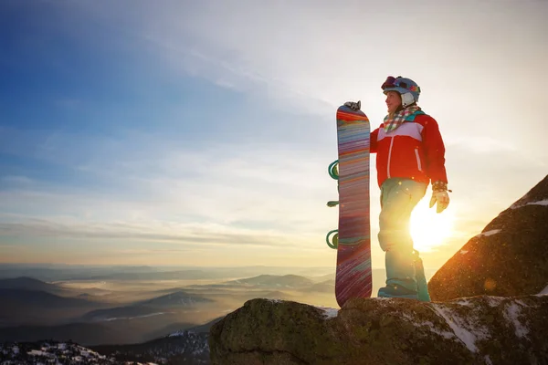 女の子のスノーボーダーは 日没の背景に山の頂上にスノーボードで立っています シェレゲシュスキー場 — ストック写真
