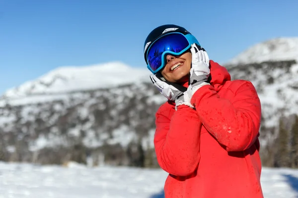 戴着头盔和面具的女滑雪者把她的手掌贴在脸上笑了 Sheregesh度假胜地 — 图库照片