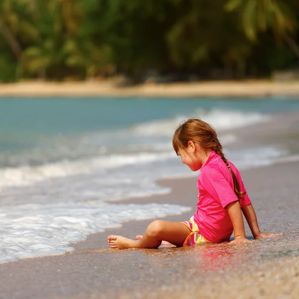 Small girl sitting on sand — Stock Photo, Image