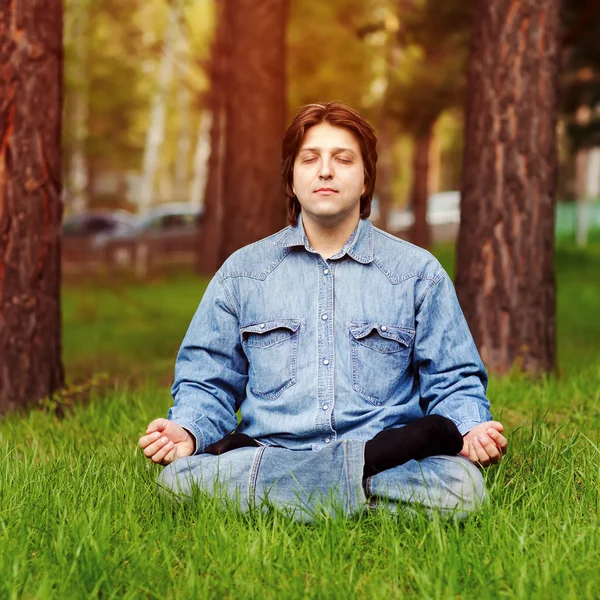 Genç adam dışarıda meditasyon yapıyor. — Stok fotoğraf