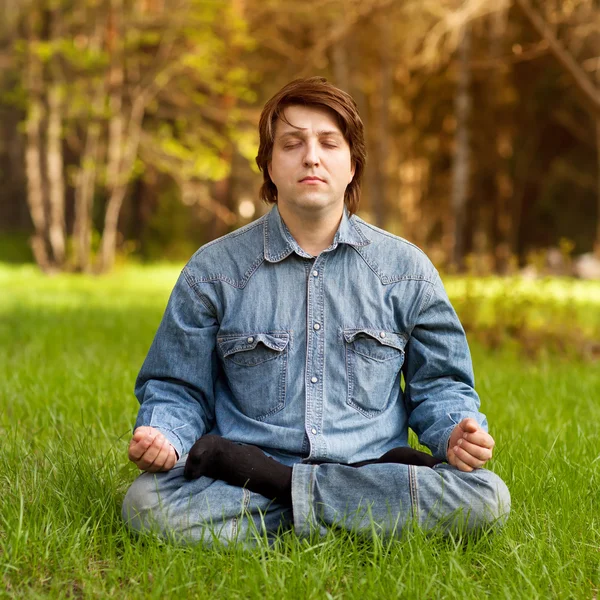 Young man meditating outdoors — Stock Photo, Image