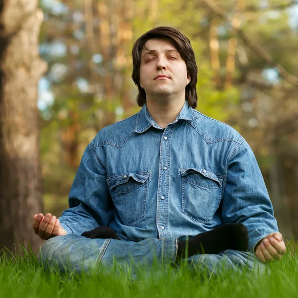Young man meditating outdoors — Stock Photo, Image