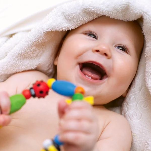 Kis mosolygós baba egy játékkal — Stock Fotó
