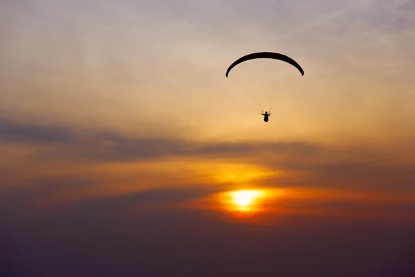 Paraglider silhuett mot bakgrund av solnedgång himlen — Stockfoto