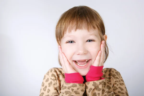 Симпатична маленька дівчинка тримає руки обличчям в несподіванці — стокове фото