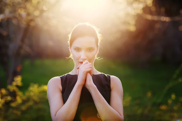 A young girl prays at sunset — Stock Photo, Image