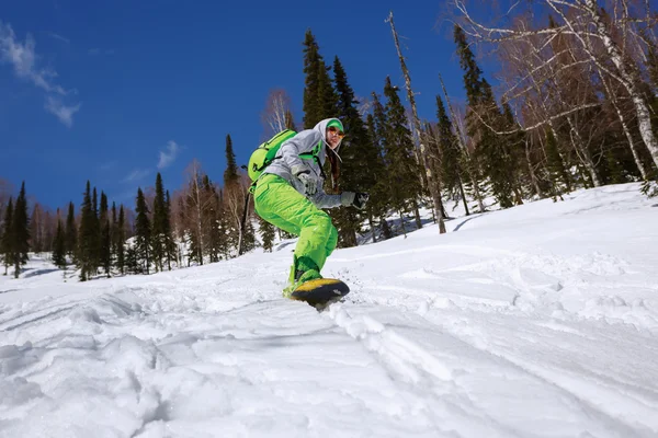 Snowboarder facendo una punta laterale intagliare con cielo blu profondo nel backgro — Foto Stock