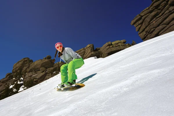 Backgro derin mavi gökyüzü ile ayak yan yapıyor snowboarder oymak — Stok fotoğraf