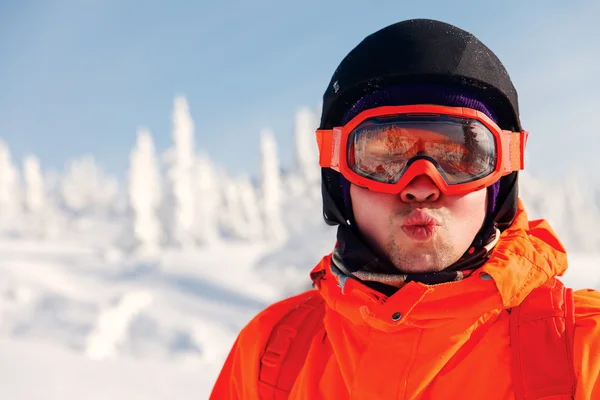 Portrait of a snowboarder in the winter resort in sunglasses mask at ski resort in mountains — Stock Photo, Image