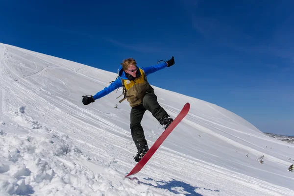 背景に深い青空を背景に空を飛び跳ねるスノーボーダー — ストック写真