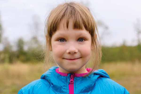 Liten flicka i blå jacka utomhus — Stockfoto