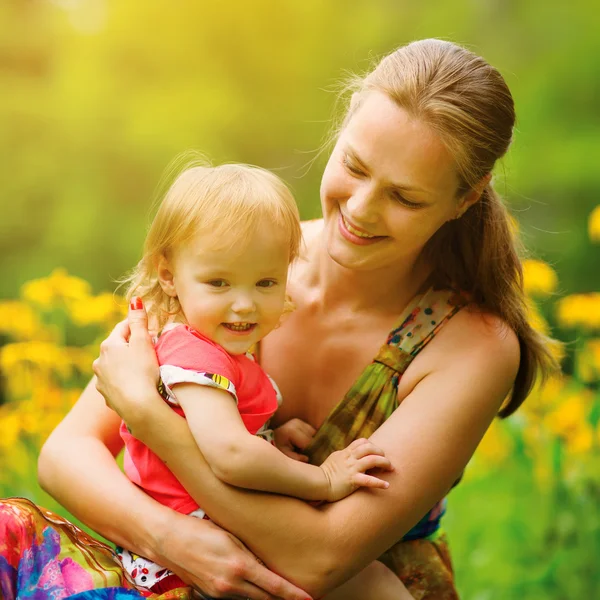 Ung mamma med sin lilla baby på ängen — Stockfoto