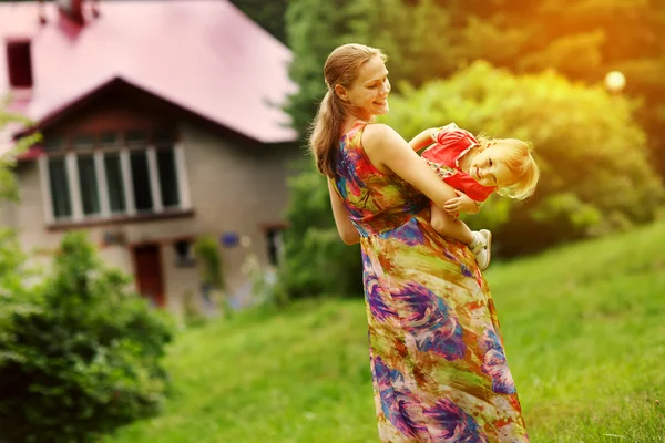 Jonge moeder met haar kleine baby op de weide — Stockfoto