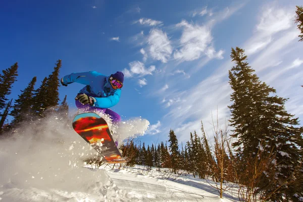 Snowboarder springen door lucht met diepblauwe lucht — Stockfoto