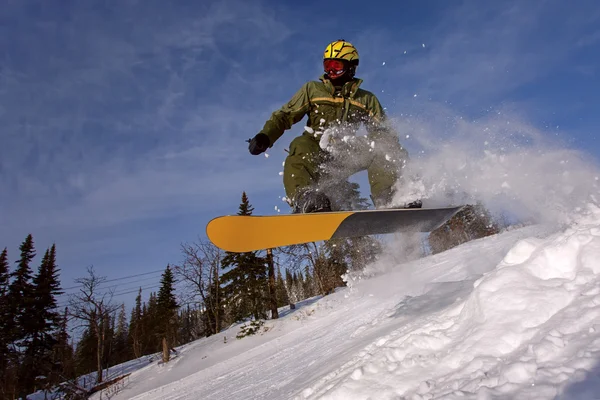 Snowboarder sautant dans l'air avec un ciel bleu profond — Photo