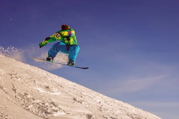 Snowboarder springen door lucht met diepblauwe lucht — Stok fotoğraf