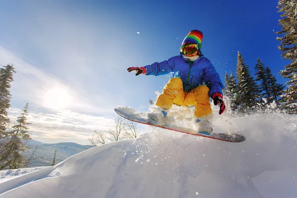 Snowboarder springen door de lucht met diep blauwe lucht op de achtergrond — Stockfoto