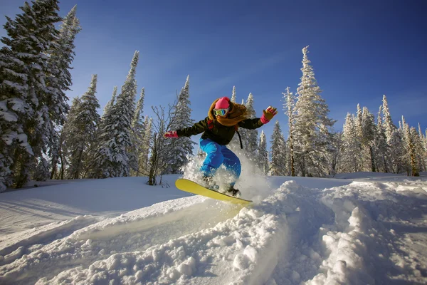 Snowboarder jumping through air with deep blue sky in background — Stock Photo, Image