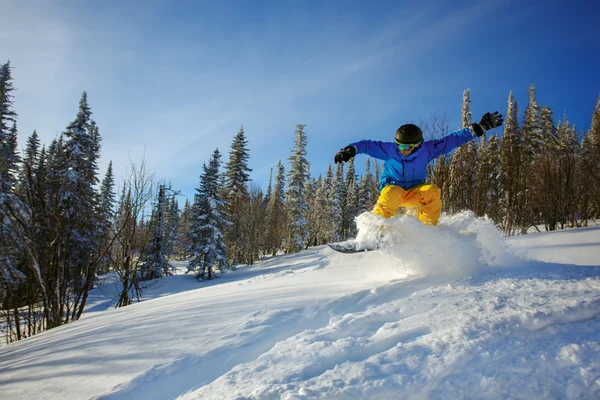 背景に深い青空を背景に空を飛び跳ねるスノーボーダー — ストック写真