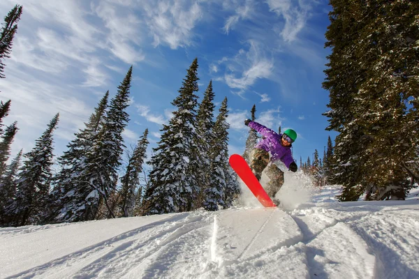 Snowboarder hoppar genom luften med djupblå himmel i bakgrunden — Stockfoto