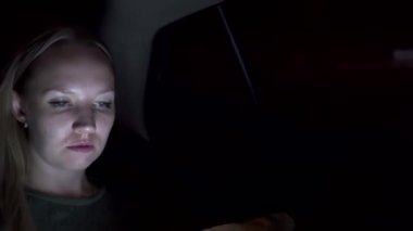 İş kadını, birinci sınıf bir arabanın arka koltuğunda telefonu kullanıyor.