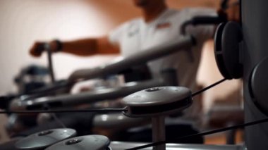 Spor salonundaki adam kollarını çalıştırıyor.
