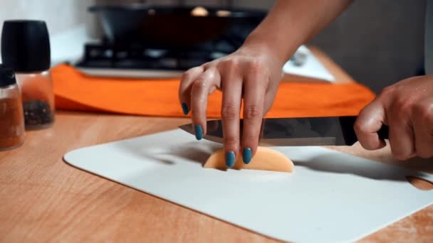 Vrouwelijke handen gesneden aardappelen met een mes — Stockvideo