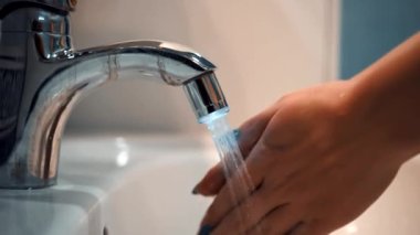 Kız ellerini yıkıyor.