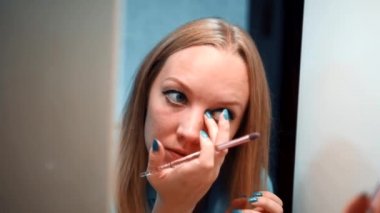 Genç kız yüzünü boyuyor.